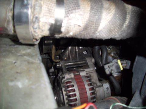 1995 Ford Probe - Close-up view of engine components, including an alternator and hoses, within a vehicle.