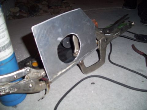 1995 Ford Probe - A metal plate with a circular cutout is clamped to a pipe, with tools and a propane torch visible in the background.