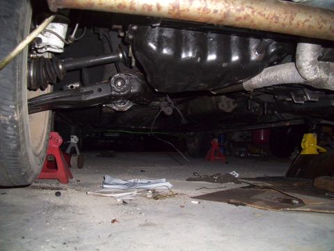 1995 Ford Probe - Car is supported by jack stands, revealing its undercarriage and mechanical parts.