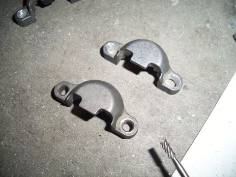 1995 Ford Probe - Two metal brackets are shown on a concrete surface next to a drill bit.