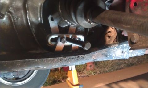 1991 Ford Festiva - Undercarriage view of a vehicle's drive axle components, supported by a jack stand.