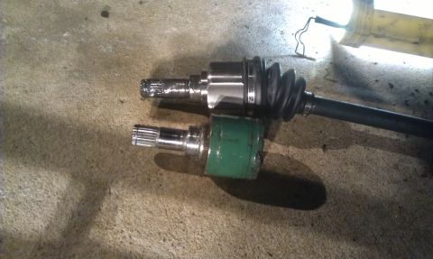 1991 Ford Festiva - Comparison of two CV axles, one with a green boot and one with a black boot.