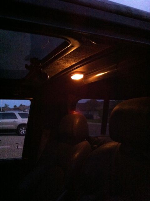 1987 Suzuki Samurai - Interior view from a dark vehicle, looking out a window at another SUV parked outside.