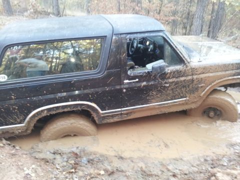 1986 Ford Bronco - This 1986 Ford Bronco is deep in the mud, with its tires submerged in the mire.