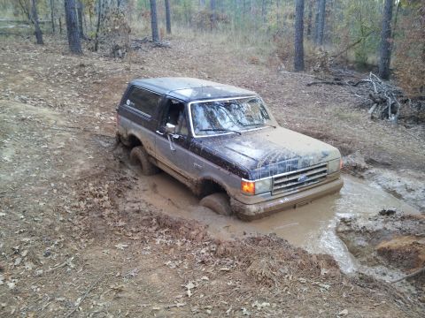 1986 Ford Bronco - This Ford Bronco is deep in the mud on an off-road trail.