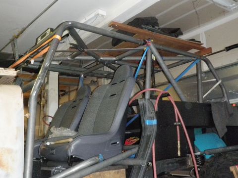 1961 International Scout 800 - Interior view of a vehicle a custom roll cage and racing seats, likely undergoing modification.