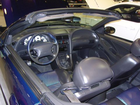 2007 Ford Mustang - The interior of a blue convertible Mustang, with a white Mustang visible in the background.