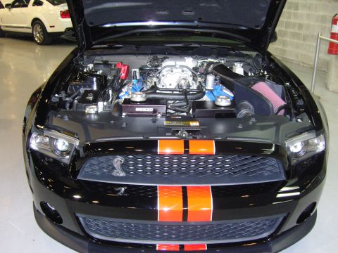 2007 Ford Mustang - Front view of a black Ford Mustang with its hood open, revealing the engine and orange racing stripes.
