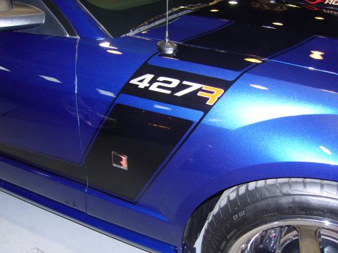 2007 Ford Mustang - Close-up of a blue car's fender racing stripes and a '427' decal.