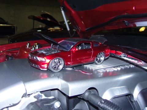 2007 Ford Mustang - A toy Ford Mustang GT sits on an engine cover, with other cars in the background.