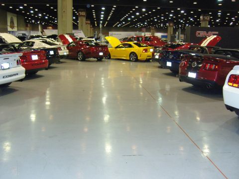 2007 Ford Mustang - A collection of Ford Mustangs are showcased at an indoor event, with multiple vehicles visible from the rear.