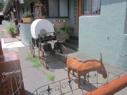 1991 Ford LTD Crown Victoria - A decorative scene a covered wagon and a metal donkey sculpture in front of a building.