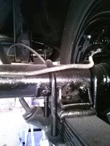 1960 Ford Falcon - Close-up view of the rear axle and leaf spring assembly, including a brake line and associated hardware.