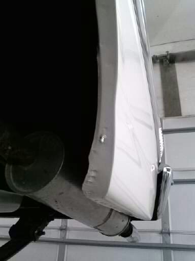 1960 Ford Falcon - Close-up of a vehicle's rear quarter panel and exhaust system, showing the underside.