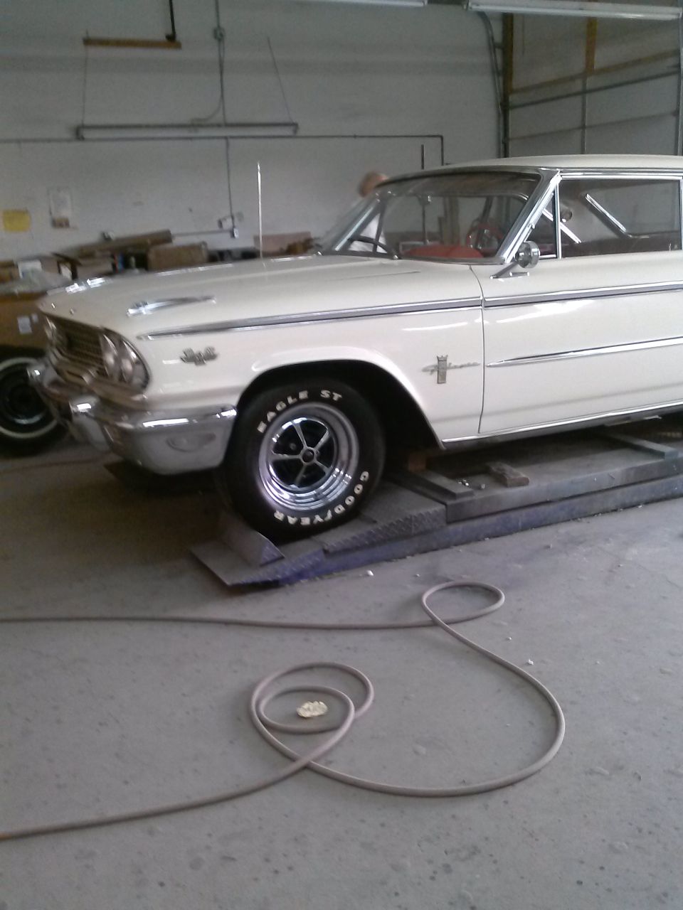 1961 Ford Falcon on a lift, front quarter view. Goodyear Eagle ST tire visible