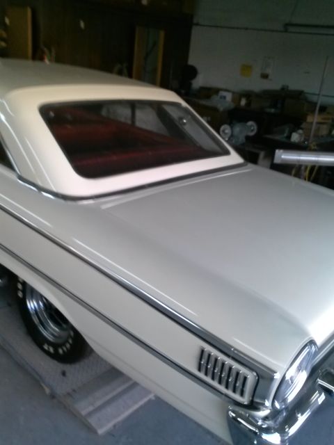 1960 Ford Falcon - Rear quarter view of a 1960 Ford Falcon coupe, showing its distinctive body lines and white exterior with a red interior.