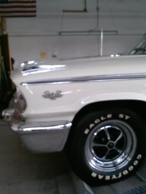 1960 Ford Falcon - A close-up view of the front quarter panel and wheel of a white 1963 Ford Galaxie 500.
