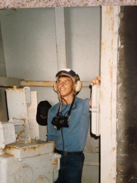 1995 Ford Bronco - A man stands in a room with industrial machinery, wearing headphones and holding a camera.