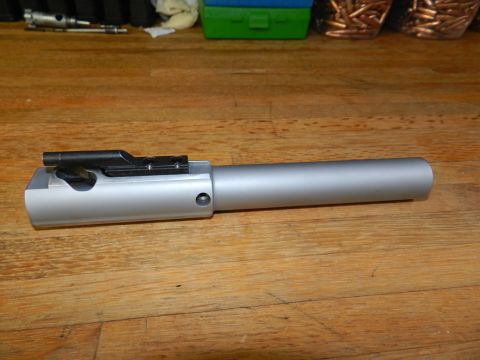 1996 Ford Bronco - A firearm bolt carrier group is shown on a wooden surface with ammunition and a toolbox in the background.