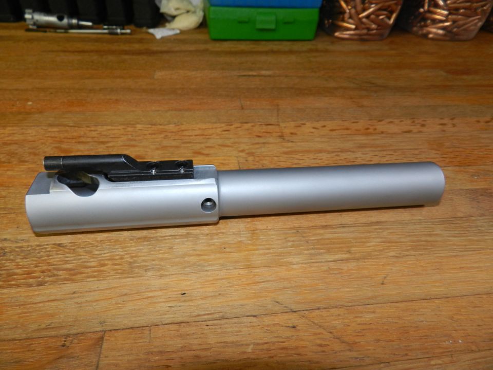 firearm bolt carrier group on wooden surface