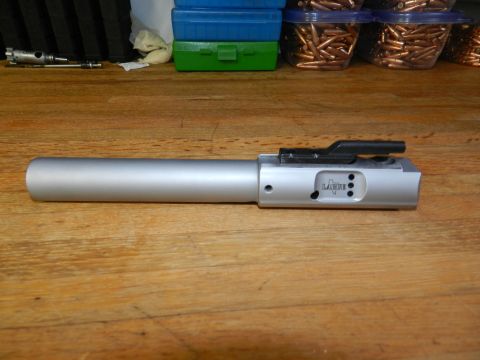 1996 Ford Bronco - A firearm bolt carrier group is shown on a wooden table, with ammunition and storage containers in the background.