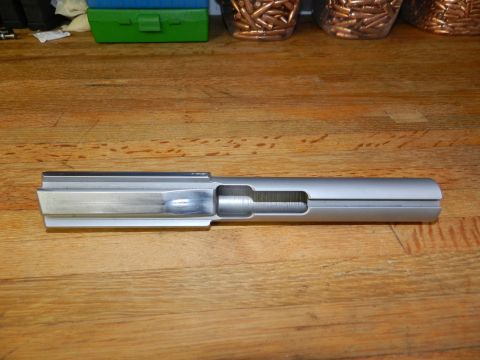 1996 Ford Bronco - Firearm slide shown on a wooden table with ammunition and a toolbox in the background.