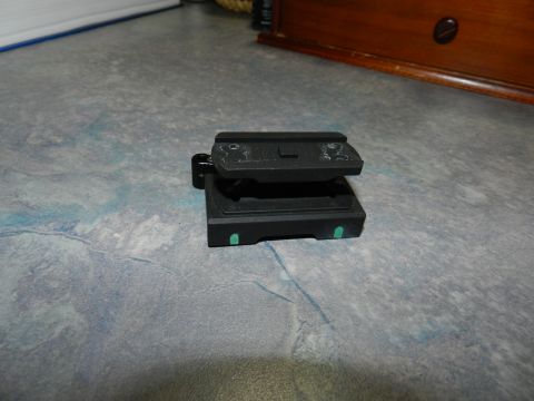 1996 Ford Bronco - A black camera tripod quick release plate is shown on a textured surface. The registry claims it is a 1996 Ford Bronco part, but this is in…
