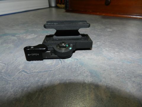 1996 Ford Bronco - Camera flash bracket with an 'OPEN' lever and adjustment dial is shown on a textured surface.