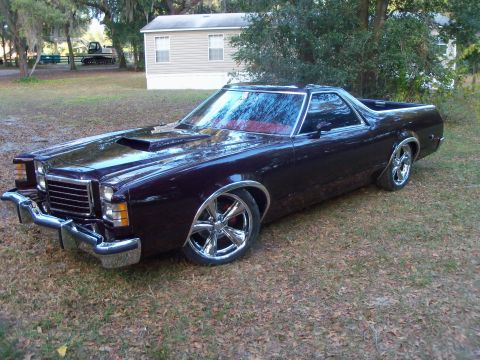 1979 Ford Ranchero - A dark maroon/black 1970s Ford Ranchero (car-based pickup) shown from a front three-quarter angle, featuring a chrome dual-loop front bumpe…