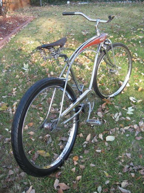 1994 Ford Bronco - A vintage cruiser bicycle with a chrome frame and a red painted tank is parked on a grassy lawn covered in autumn leaves.