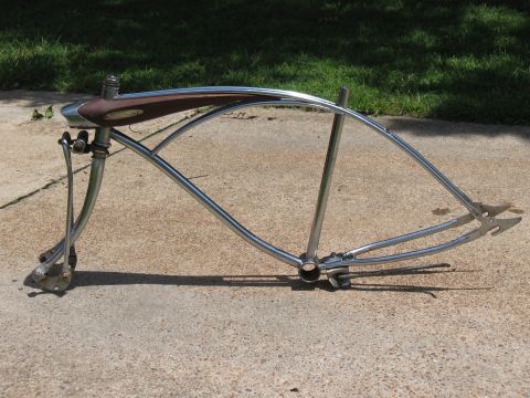 1994 Ford Bronco - A chrome bicycle frame with a brown seat and curved handlebars rests on a concrete surface.