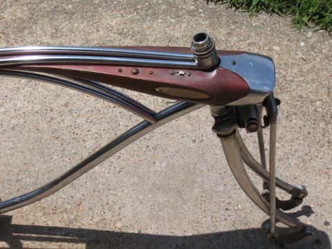 1994 Ford Bronco - Detail of an old bicycle's front fork, chrome tubing and a maroon-colored section.