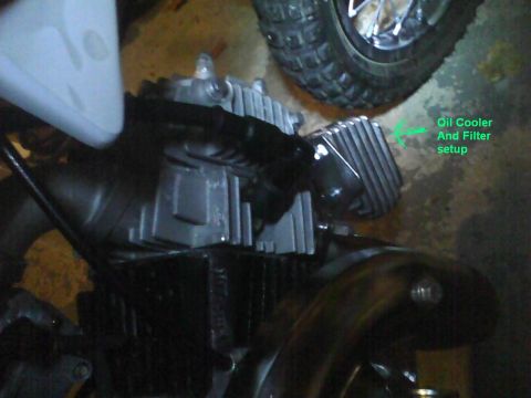 2003 Ford Crown Victoria - Close-up view of a motorcycle engine, highlighting the oil cooler and filter setup with a green annotation.