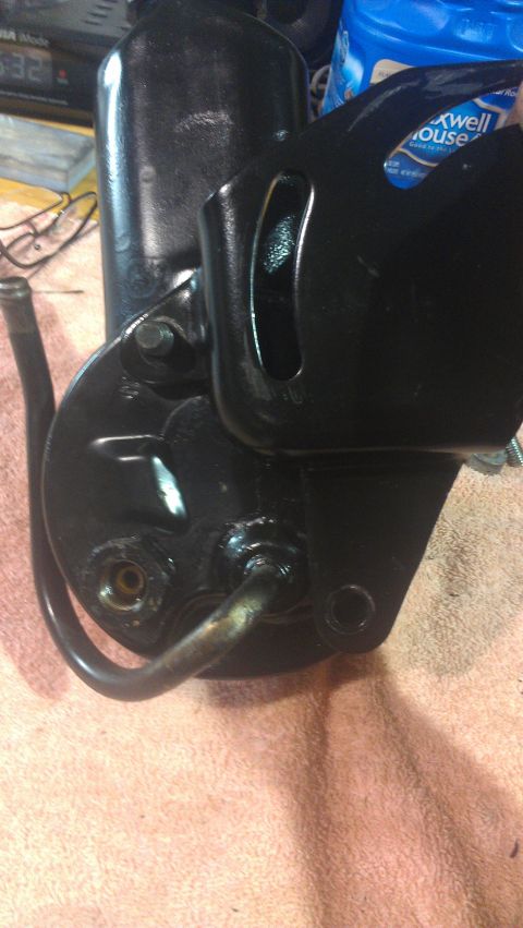 1973 Chevrolet Camaro - A black power steering pump with attached metal lines is shown in close-up, resting on a towel.