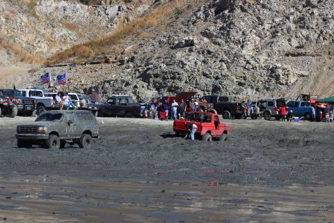 1978 Ford Bronco - Off-road vehicles participate in a mud bogging event at a rocky hillside venue.