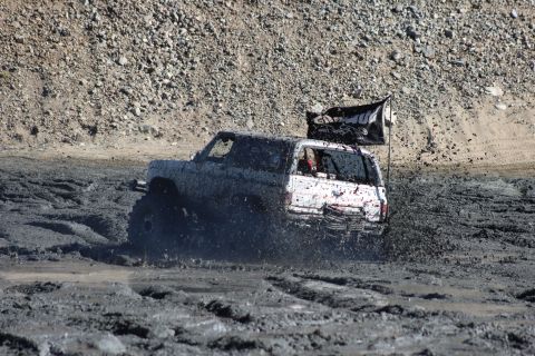 1978 Ford Bronco - This off-road vehicle navigates a challenging muddy terrain, with a flag trailing behind.