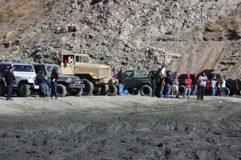 1978 Ford Bronco - A group of people and various off-road vehicles are gathered in a sandy, rocky area.