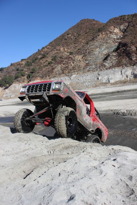 1978 Ford Bronco - This heavily modified off-road vehicle, possibly from the early 1980s, tackles a sandy incline with its suspension clearly visible.