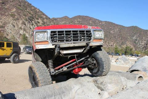 1978 Ford Bronco - This modified SUV is navigating a rocky trail with other vehicles present.