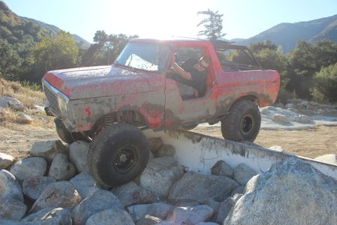 1978 Ford Bronco - This red SUV is navigating a rocky obstacle course on a sunny day.