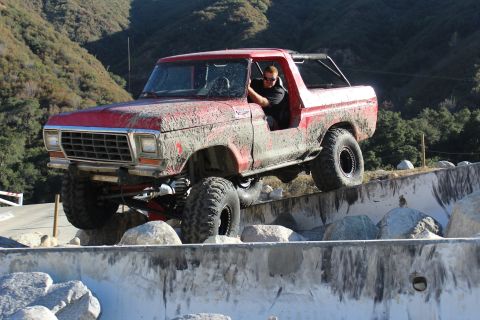 1978 Ford Bronco - Mud-covered 1978 Ford Bronco navigates a challenging off-road obstacle course.