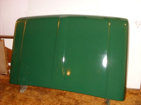 1967 Ford F-250 - A green truck hood is shown indoors, resting on supports.