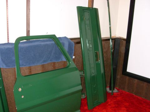 1967 Ford F-250 - Green truck door and tailgate with "FORD" embossed on the tailgate, displayed indoors.