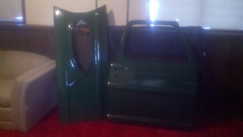 1967 Ford F-250 - A green truck door and fender are shown indoors, leaning against a wall.