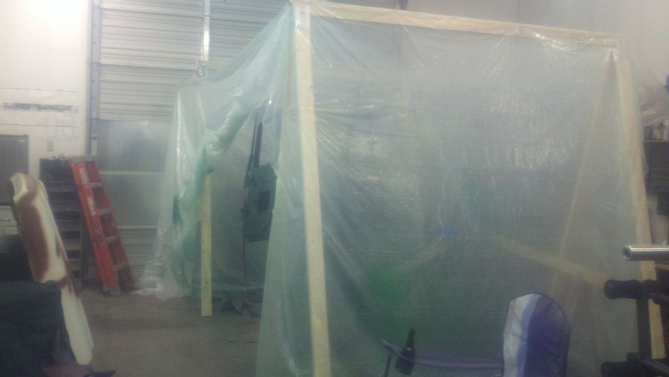 Plastic sheeting covers a wooden frame in a workshop