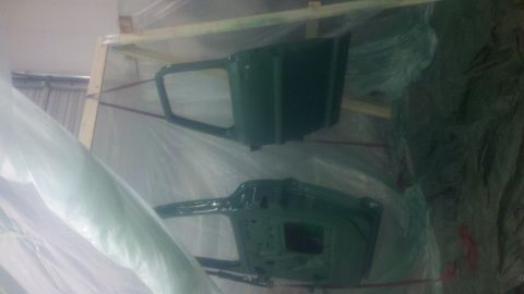 1967 Ford F-250 - Two green truck doors are stored in a wooden crate, wrapped in protective plastic sheeting.
