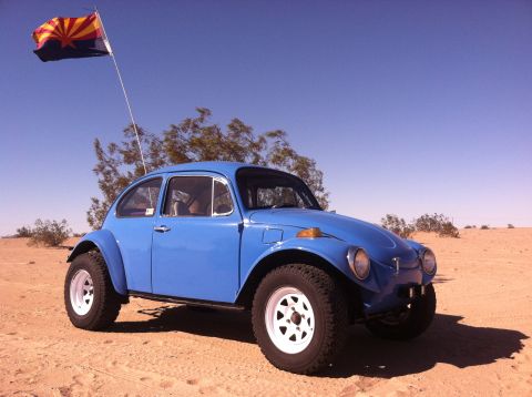 1970 Volkswagen Beetle - Modified Volkswagen Beetle with off-road tires and a lifted suspension sits in a sandy desert landscape.