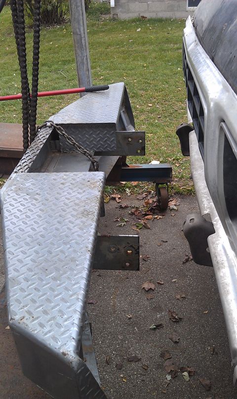 1979 Ford Bronco - A custom diamond plate bumper is attached to a trailer hitch, with a portion of a vehicle's grille visible.