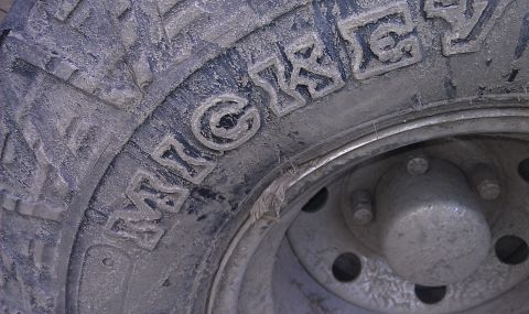1979 Ford Bronco - A close-up view of a tire with visible tread and lettering, along with part of the wheel hub.