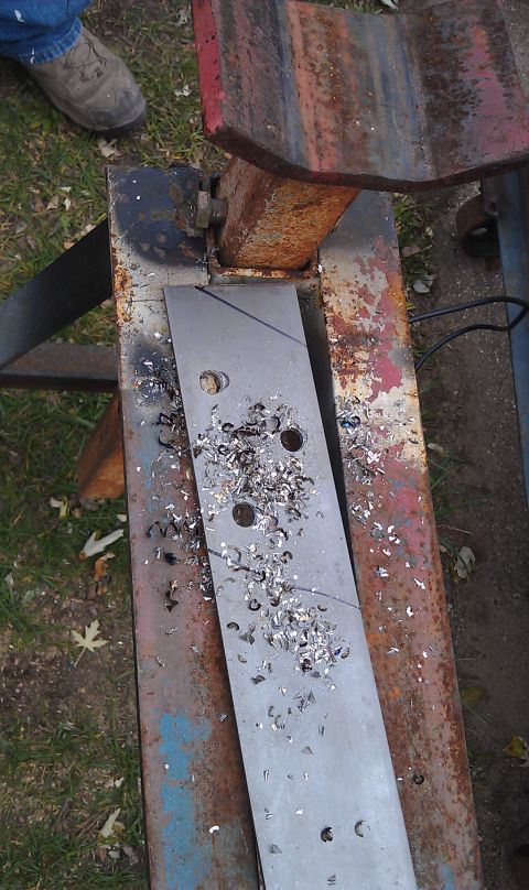 1979 Ford Bronco - A metal plate is being worked on, with metal shavings scattered around the drilled holes.